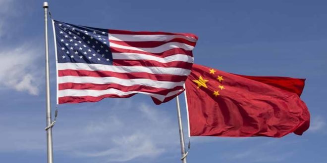 American Chinese windy day flags fly together on flagpole